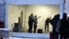 FILE - Royal Canadian Mounted Police, left, search migrants after their arrival at a reception center for irregular borders crossers, in Saint-Bernard-de-Lacolle, Quebec, in Canada, Jan. 12, 2022, in a photo taken from Champlain, N.Y.