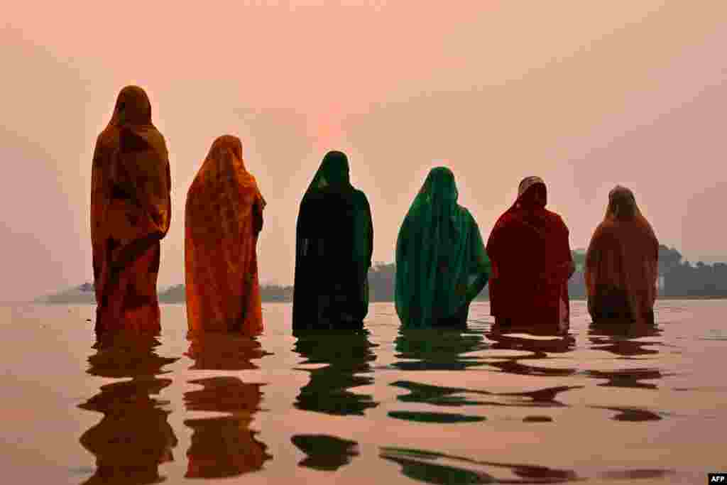 Hindu devotees offer prayers to the Sun god on the banks of river Brahmaputra during &#39;Chaiti Chhath Puja&#39; festival in Guwahati, India.