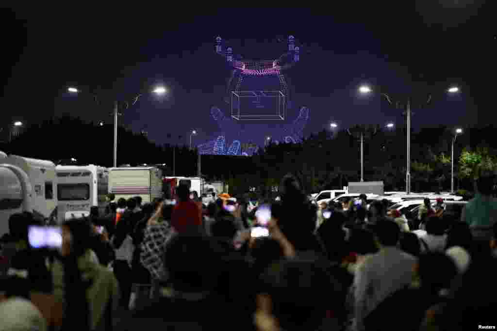 People watch drones&#39; formation flying at the World Drone Light Show 2024, which is a part of the 2024 Korea Drone Expo, in Incheon, South Korea.