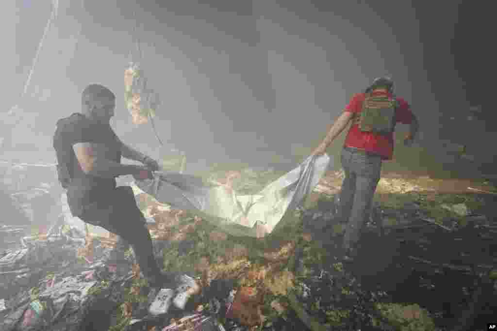 Rescuers carry a body after a Russian missile hit a large printing house in Kharkiv, Ukraine.&nbsp; At least seven civilians were killed, officials said, as Kyiv&rsquo;s army labored to hold off an intense cross-border offensive by the Kremlin&rsquo;s larger and better-equipped forces.