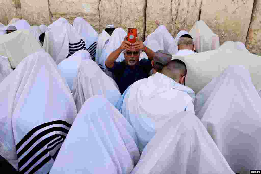 Jewish worshippers cover themselves in their prayer shawls, as they pray during a priestly blessing on the Jewish holiday of Passover, at the Western Wall, Judaism&#39;s holiest prayer site, followed by a special pray for the hostages held in Gaza, the well-being of the Israeli soldiers, the Jewish nation and for healing of the injured, in Jerusalem&#39;s Old City.