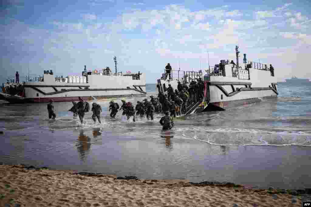 French troops disembark from a U.S. landing craft during a joint U.S. and French amphibious landing operation showcase at Omaha beach in Saint-Laurent-sur-Mer, northwestern France, ahead of the &quot;D-Day&quot; commemorations marking the 80th anniversary of the World War II Allied landings in Normandy.