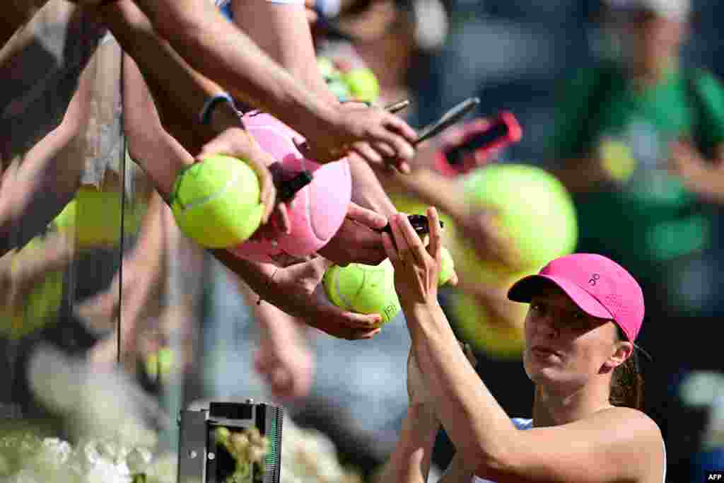 Poland&#39;s Iga Swiatek signs autographs after winning against Germany&#39;s Angelique Kerber during the Women&#39;s WTA Rome Open tennis tournament at Foro Italico in Rome, Italy.