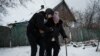 A volunteer Andrey (L), 38, helps Lydia Ivanovna, 62, to evacuate in Chasiv Yar, Feb. 15, 2023, amid the Russian invasion of Ukraine.
