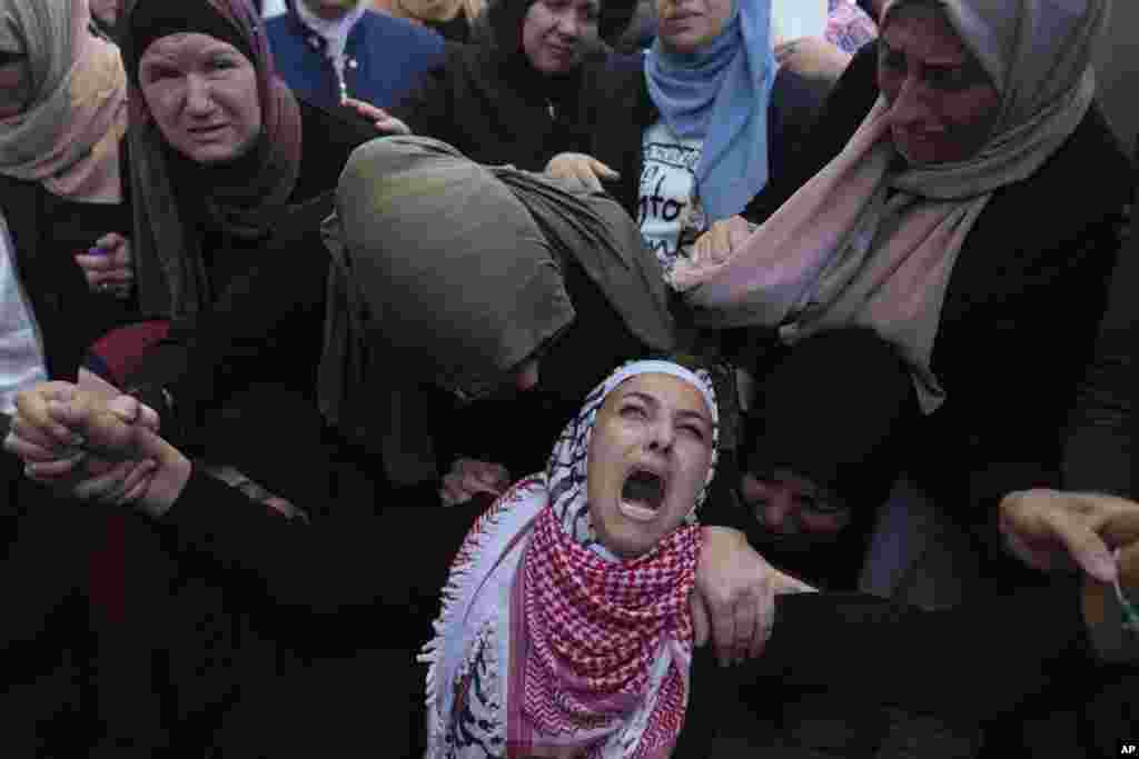 Palestinian Fayrouz Safi cries while she takes the last look at the body of her son Aysar Safi, 20, at the family house during his funeral in the West Bank refugee camp of Jalazoun, north of Ramallah.&nbsp;Safi was killed during clashes with Israeli forces at the northern entrance of al-Bireh city, Palestinian ministry of health said.