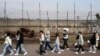 FILE - People pass by a wire fence at the Imjingak Pavilion in Paju South Korea, near the border with North Korea, March 24, 2023. 