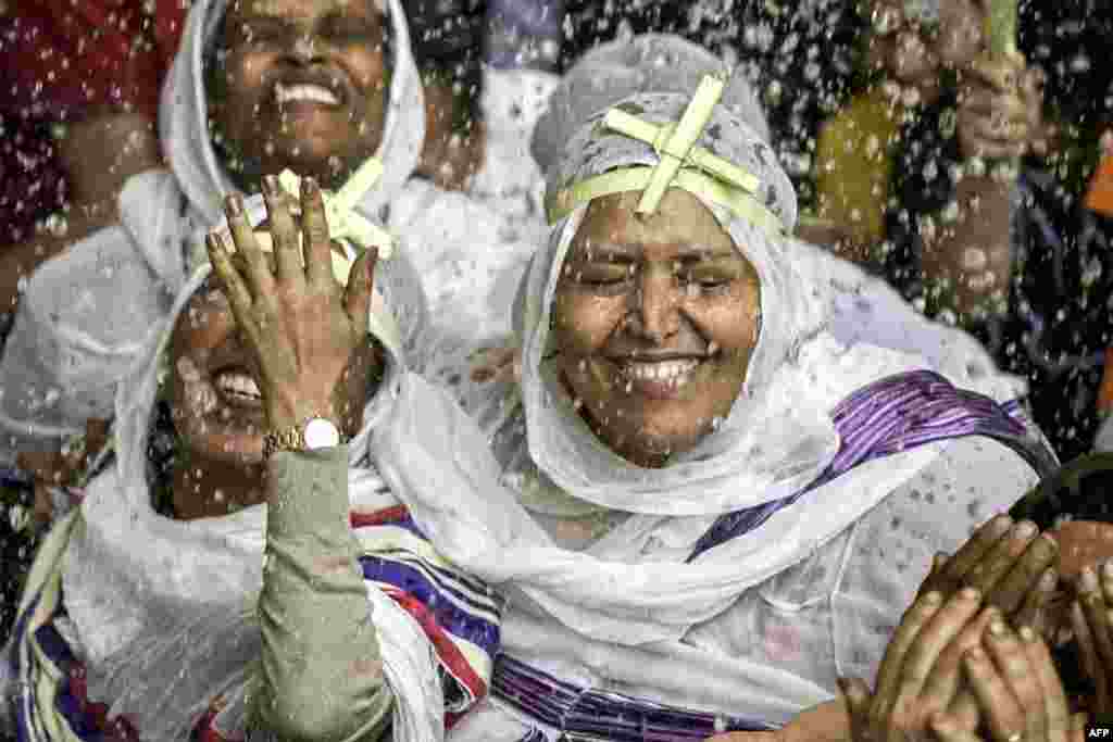 Ethiopian Christian worshipers are sprinkled with holy water during the Palm Sunday service at the Coptic Orthodox Monastery of Simon the Tanner,&nbsp;also known as the Cave Church,&nbsp;in the eastern hillside Mokkatam district of Cairo, Egypt.
