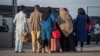 Afghan refugees who supported Canada's mission in Afghanistan prepare to board buses after arriving in Canada, at Toronto Pearson International Airport, Aug. 24, 2021. (Canadian Armed Forces via Reuters)