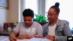 Adriane Burnett helps her son Josiah with his studies April 14, 2024, in Birmingham, Ala.