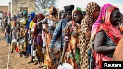FILE - Women who fled the war-torn Sudan line up to receive food rations at the United Nations High Commissioner for Refugees transit center near the border crossing point in Renk County of Upper Nile State, South Sudan May 1, 2023. 