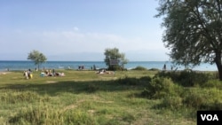 A group of local residents relax at the beach near the city of Balykchi in the Issyk Kul province, Kyrgyzstan, June 10, 2024. Balykchi is 48.2 kilometers west of the proposed site for Asman city. 