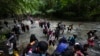 FILE - Migrants, mostly Venezuelans, cross a river during their journey through the Darien Gap from Colombia into Panama, hoping to reach the US, Oct. 15, 2022. 