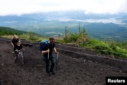Climbers walk on Fuji Yoshidaguchi Trail (Yoshida Route) on the first day of the climbing season on the slopes of Mount Fuji, in Fujiyoshida, Yamanashi Prefecture, Japan, July 1, 2024.