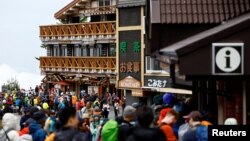 Climbers and visitors gather on the first day of the climbing season at Fuji Yoshidaguchi Trail (Yoshida Route) at the fifth station on the slopes of Mount Fuji, in Fujiyoshida, Yamanashi Prefecture, Japan, July 1, 2024. 