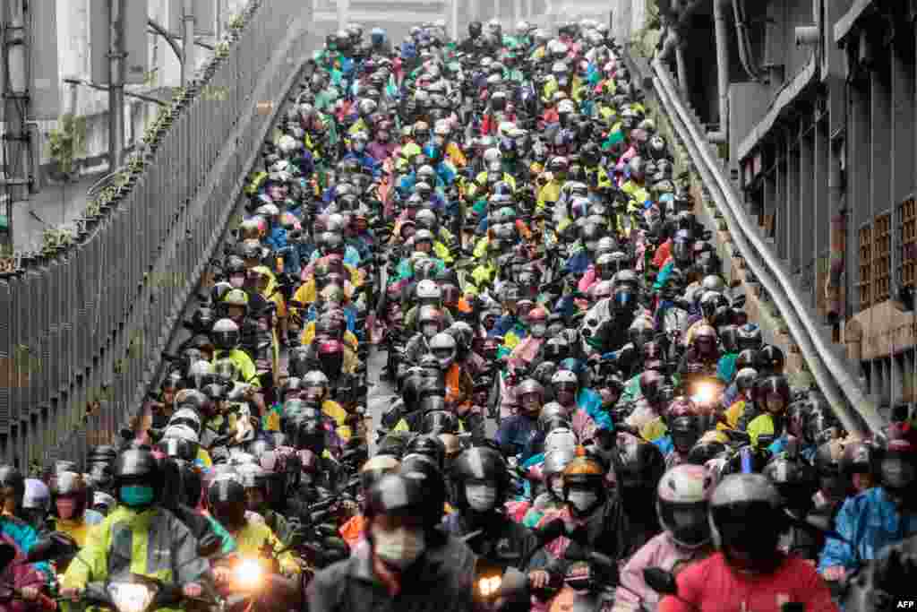 Motorcyclists ride down from the exclusive motorcycle lane of the Taipei Bridge during the morning commute in Taipei, Taiwan.
