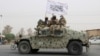 FILE - Taliban fighters patrol on the road during a celebration marking the second anniversary of the withdrawal of US-led troops from Afghanistan, in Kandahar, south of Kabul, Afghanistan, Aug. 15, 2023. 