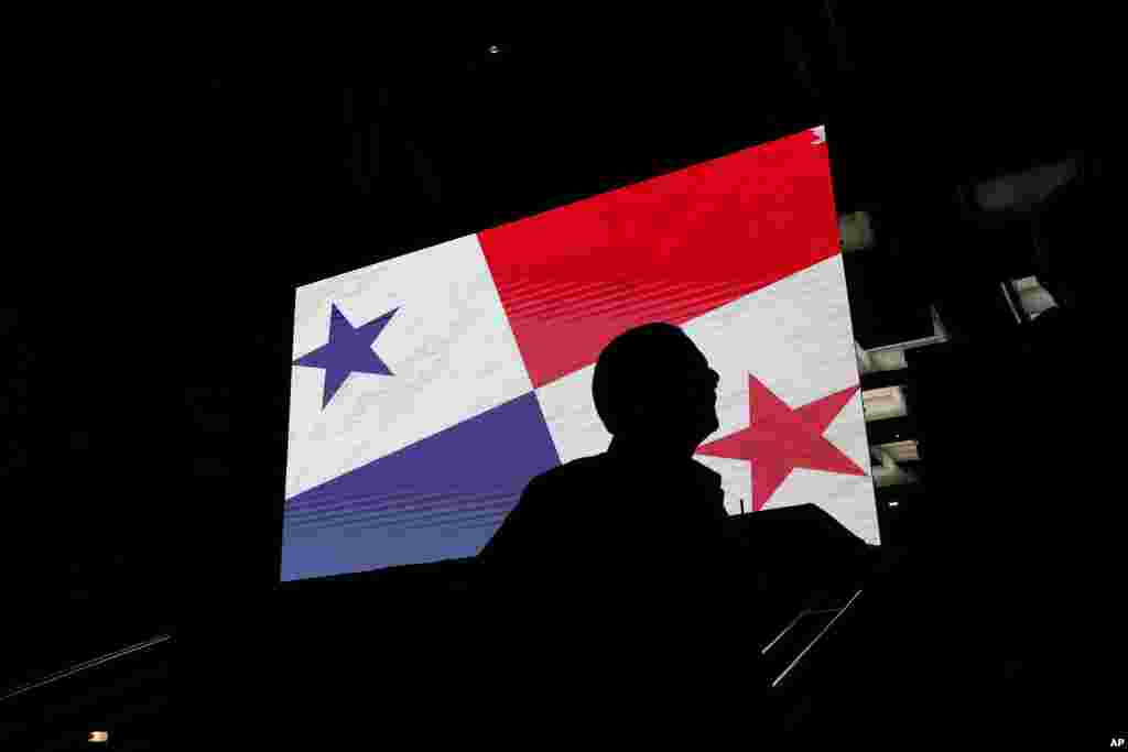 A supporter of Achieving Goals presidential candidate Jose Raul Mulino stands near a screen of a Panamanian flag outside his campaign headquarters as he waits for general election results in Panama City, May 5, 2024. 