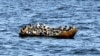 FILE - Para migran asal Afrika yang mencoba melarikan diri ke Eropa berdesakan di perahu kecil, saat penjaga pantai Tunisia bersiap untuk memindahkan mereka ke kapal mereka, di laut antara Tunisia dan Italia, 10 Agustus 2023. (FETHI BELAID / AFP)