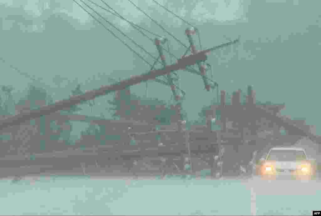 A car drives past power lines downed by the high winds from Typhoon Koinu in Taiwan&#39;s southern Pingtung County, Taiwan.