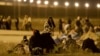Migrants wait in the cold at a gate in the border fence after crossing from Ciudad Juarez, Mexico, into El Paso, Texas, in the early hours of May 11, 2023. 