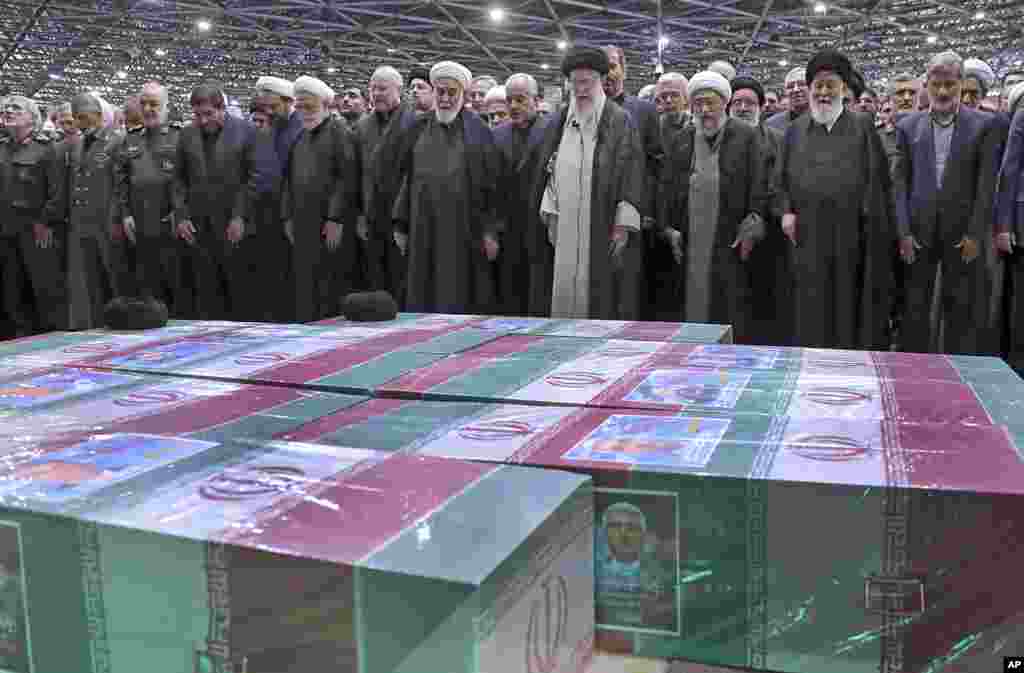 In this photo released by the office of the Iranian supreme leader, Supreme Leader Ayatollah Ali Khamenei, center right, leads a prayer over the flag-draped coffins of the late President Ebrahim Raisi and his companions who were killed in a helicopter crash, at the Tehran University campus, during a funeral ceremony for them in Tehran.&nbsp;