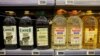 FILE - Olive and sunflower oil bottles are displayed for sale, protected by a padlock and a chain to prevent theft, in a Tu Super Suma supermarket in Malaga, Spain, Oct. 23, 2023.