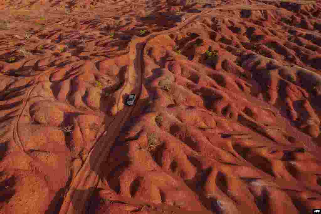Aerial view showing a car riding along a dirt road in the Desert of Gilbues, in Gilbues, in the northeastern state of Piaui, Brazil. Gilbues is Brazil's worst desertification hotspot, where a parched, canyon-pocked landscape is swallowing up farms and residences, claiming an area bigger than New York City. 