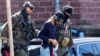 A 26-year-old Syrian man, who is the suspect in custody for a stabbing rampage in the western German city of Solingen, is escorted by police as he leaves the Federal Public Prosecutor's Office in Karlsruhe, Germany, Aug. 25, 2024.