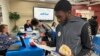 Job seeker Johannes Oveida looks over a brochure at a job fair at Lehigh Carbon Community College in Allentown, Pennsylvania, March 7, 2024. 
