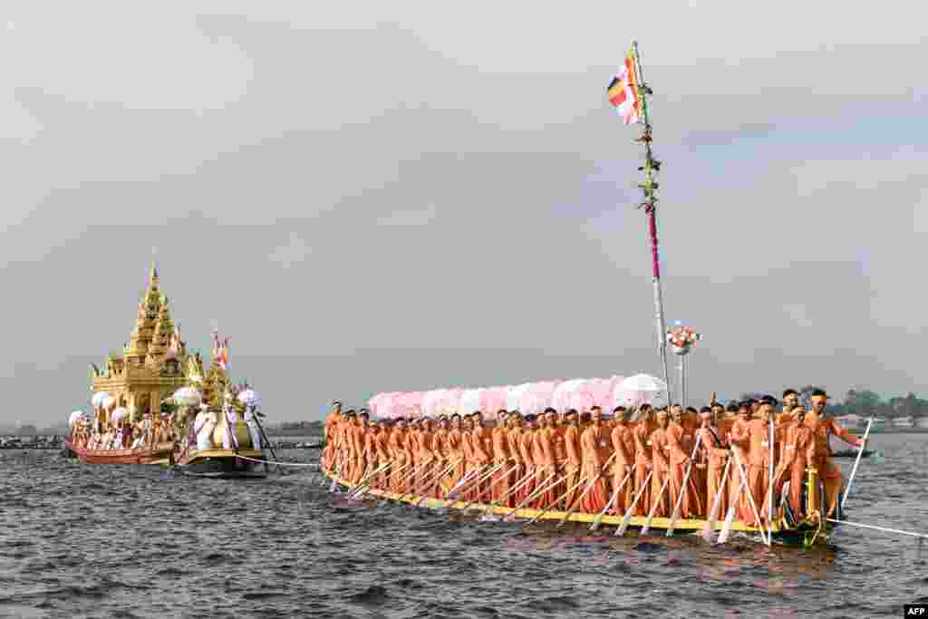 Devotees row in front of the four sacred Buddha images placed on a golden barge (L) during the festival of Phaung Daw Oo Pagoda in Inle Lake, Myanmar&#39;s Shan State.&nbsp;Thousands of Buddhist devotees joined a waterborne procession as one of the country&#39;s biggest festivals returned to joy and sorrow as conflict between the military and its opponents rages on.&nbsp;