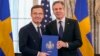 Secretary of State Antony Blinken, right, poses for a photo with Swedish Prime Minister Ulf Kristersson holding Sweden's NATO Instruments of Accession in the Benjamin Franklin Room at the State Department, in Washington, March 7, 2024.