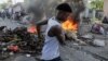 Yon gason kouri bo kote yon barikad kap boule pandan yon manifestasyon kont gouvenman an ak ogmantasyon pri petwol la nan Potoprens, Ayiti, 3 Oktob, 2022. 
