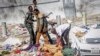 Rescuers and security forces stand by a dead body at the scene of a double car-bomb attack in Mogadishu, Somalia, Oct. 29, 2022. 
