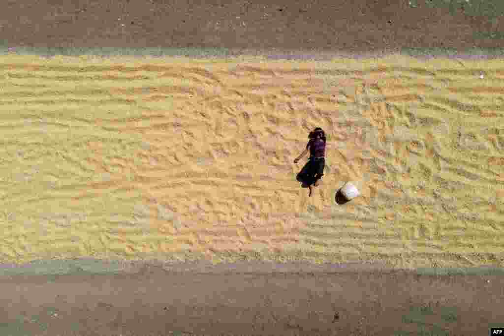 An aerial view shows a boy resting on drying corn near agricultural fields in the village of Jindayris in the Afrin region of Syria&#39;s rebel-held northern Aleppo province, Syria.