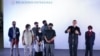 FILE - Afghan journalist refugees stand during a welcoming ceremony by Mexican Foreign Minister Marcelo Ebrard, speaking, upon arrival to Benito Juarez International Airport in Mexico City, Aug. 25, 2021.