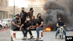 Pendukung ulama Syiah Irak Muqtada al-Sadr berkumpul di jalan yang diblokir dengan ban-ban yang dibakar, selama aksi demonstrasi di kota Basra, Irak selatan, Senin 29 Agustus 2022.