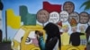 FILE - Seorang pemuda menggunakan ponselnya di depan mural kampanye Pemilu 2019, Banda Aceh, 17 Maret 2019. (Foto: AFP/CHAIDEER MAHYUDDIN)