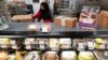 FILE - Madina Safi works in the bakery department at a grocery store in Alexandria, Va., April 14, 2022. She and her family were evacuated from Afghanistan and are trying to make a new life in the U.S.