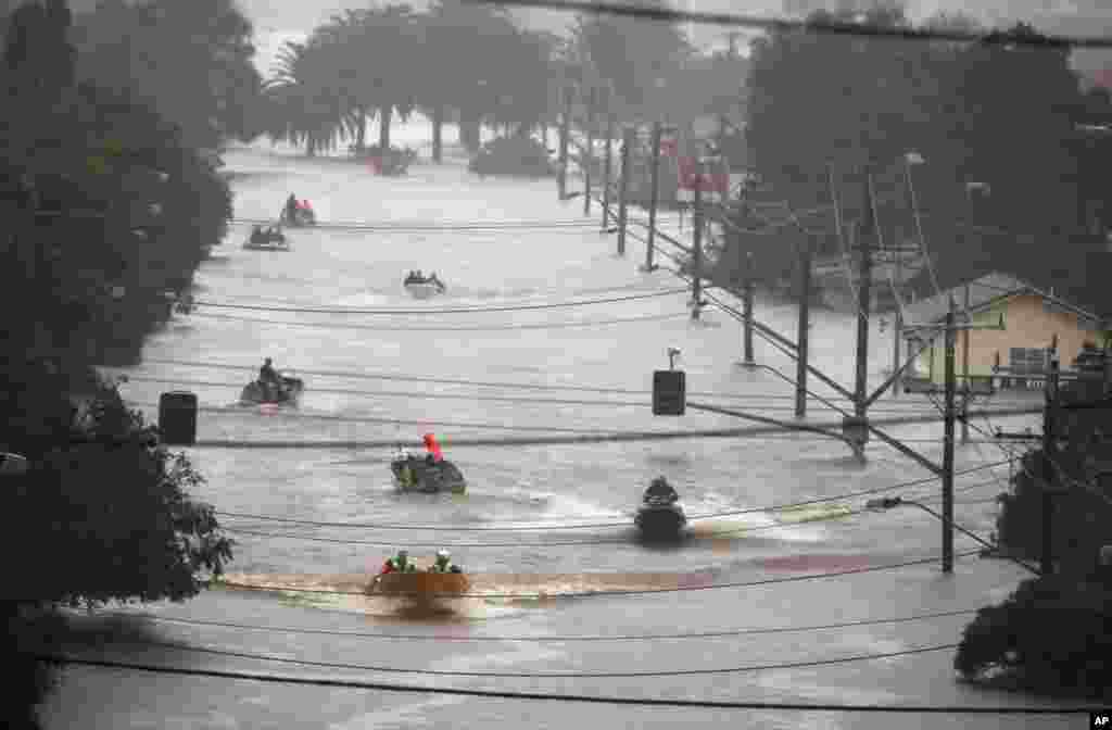 People use small boats to travel through flood water in Lismore, Australia, Feb. 28, 2022.&nbsp;Heavy rain is bringing record flooding to some east coast areas and claimed seven lives while the flooding in Brisbane, a population of 2.6 million, and its surrounds is the worst since 2011.