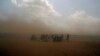 Syrian refugees enter Turkey during a sand storm at Yumurtalik crossing gate near Suruc, Turkey, Sept. 24, 2014.