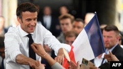 Le président français et candidat du parti centriste La République en marche (LREM) à la réélection, Emmanuel Macron, serre la main de ses partisans alors qu'il organise un rassemblement le dernier jour de la campagne, à Figeac, dans le sud de la France, le 22 avril 2022.