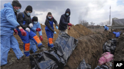 maiti wakizikwa katika makaburi ya pamoja Mariupol, Ukraine 