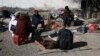 FILE - Migrants sit around a fire at a shelter on the U.S.-Mexico border in Ciudad Juarez, Mexico, Dec. 19, 2022.