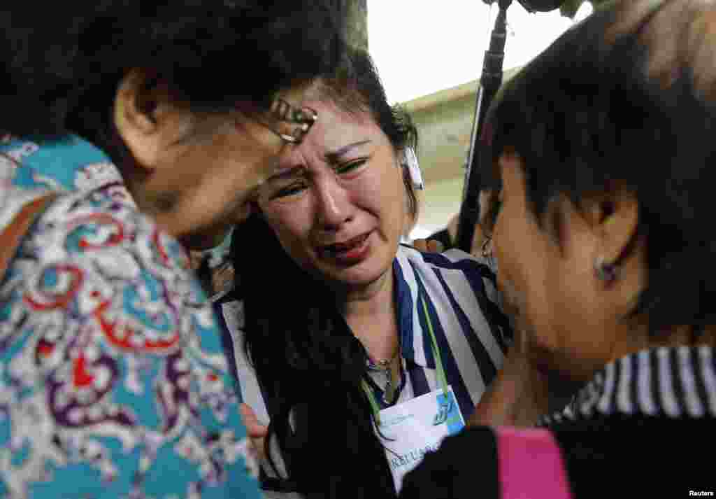Les proches des passagers qui avaient dans le vol 8501 d'AirAsie pleurent et crient dans une zone d'attente à l'aéroport international de Juanda à Surabaya, en Indonésie, le 29 décembre 2014.