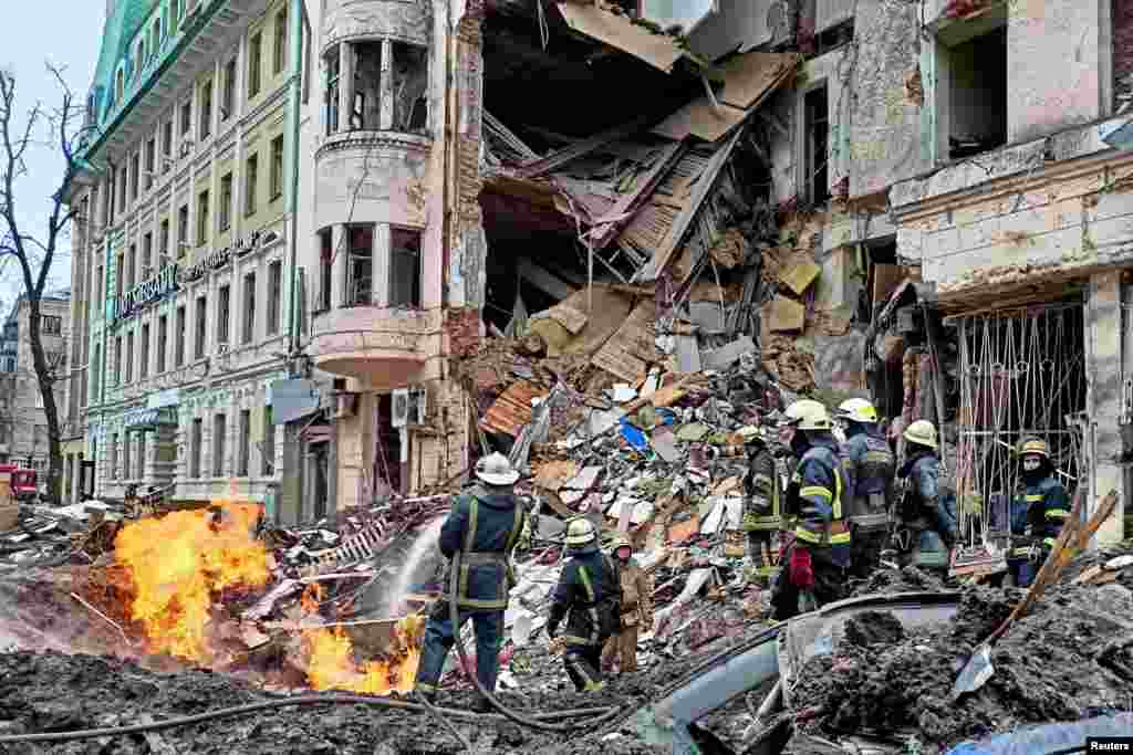 Rescuers work next to a building damaged by airstrike in central Kharkiv, as Russia&#39;s attack on Ukraine continues.