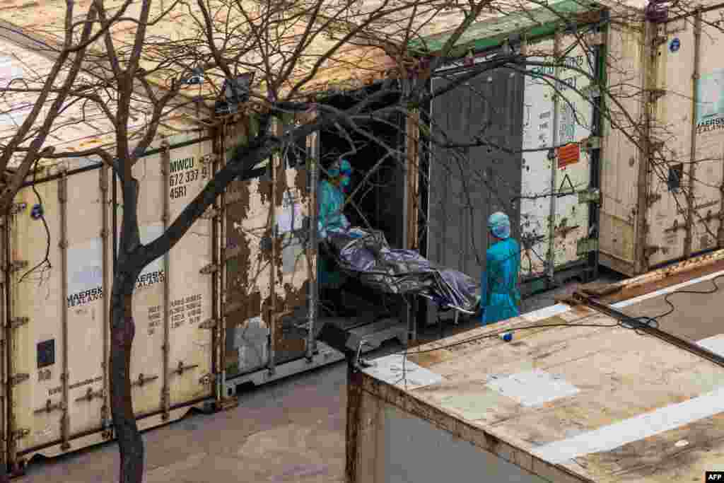 Workers move the body of a deceased person from a truck into a refrigerated container at the Fu Shan Public Mortuary in Hong Kong, amid the city&#39;s worst-ever COVID-19 outbreak.