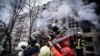 Des pompiers ukrainiens évacuent un homme d'un immeuble touché par un bombardement à Kiev, en Ukraine, le lundi 14 mars 2022, lors du conflit entre la Russie et l'Ukraine. (Photo AP/Service d'urgence de l'État ukrainien)