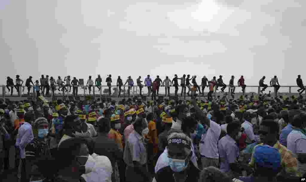 Supporters of Sri Lanka&#39;s main opposition sit on the fence of the Chinese-owned Port City project as they gather to protest outside the president&#39;s office in Colombo.&nbsp;The protesters were demanding the resignation of President Gotabaya Rajapaksa, as the country suffers one of the worst economic crises in its history.