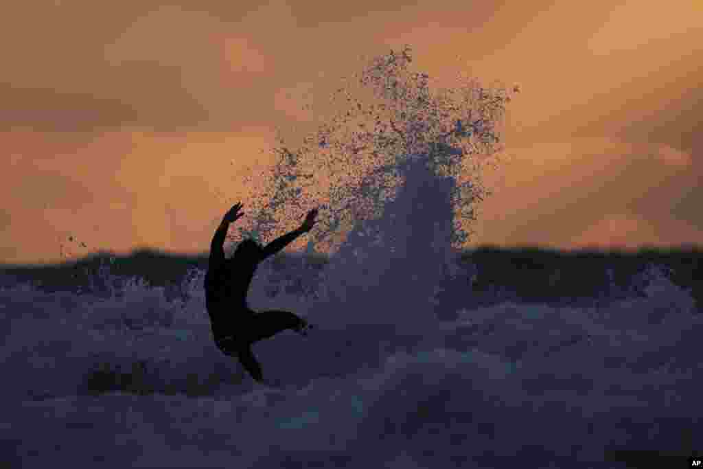 A professional surfer maneuvers on a wave in the Mediterranean Sea after competing in the first round of the Qualifying Series of the world Surf League event in Netanya, Israel.
