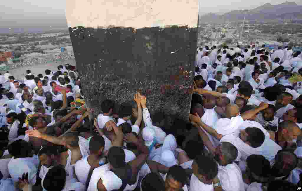 Para jamaah Haji berdoa di bukit berbatu di Jabal Rahmah, yang terletak di Padang Arafah, dekat kota suci Mekkah, Arab Saudi.